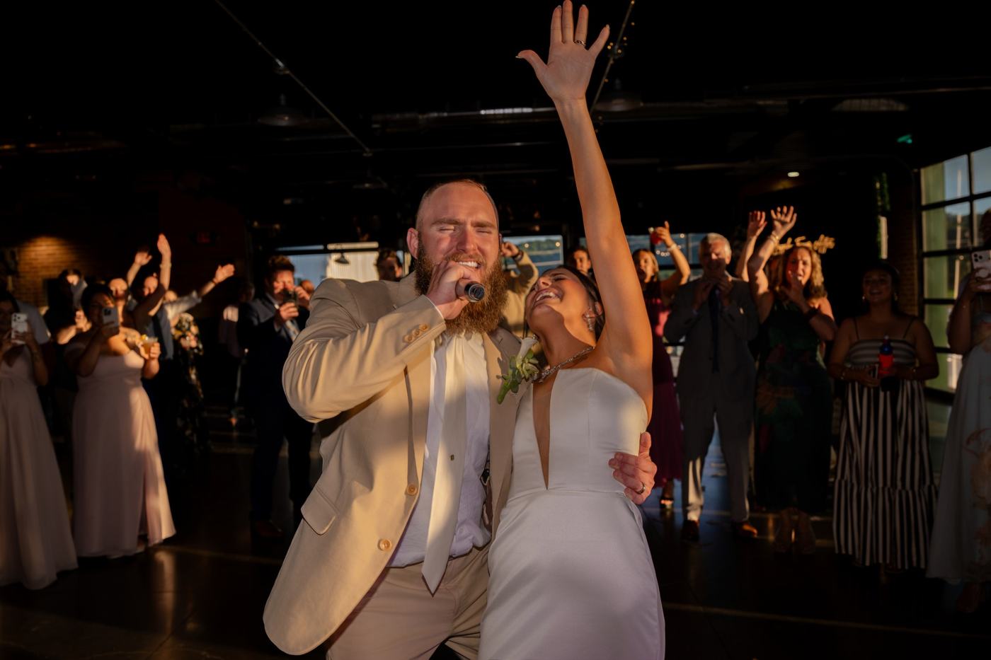 Newlyweds singing and laughing together at their reception